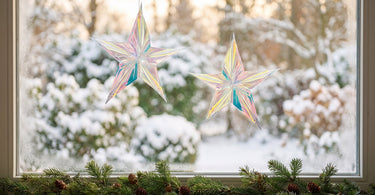 Aikito stjerne juleornament i plastik, klar, sæt med 2 fra Bloomingville, stillet op i et stemningsbillede til artiklen Julepynt til vinduer og døre: idéer, der lyser op