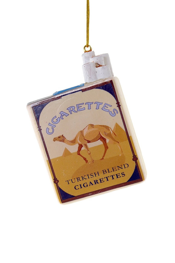Juleornament i glas formet som en blå/gul cigaretpakke med teksten CIGARETTES, håndmalet af Cody Foster